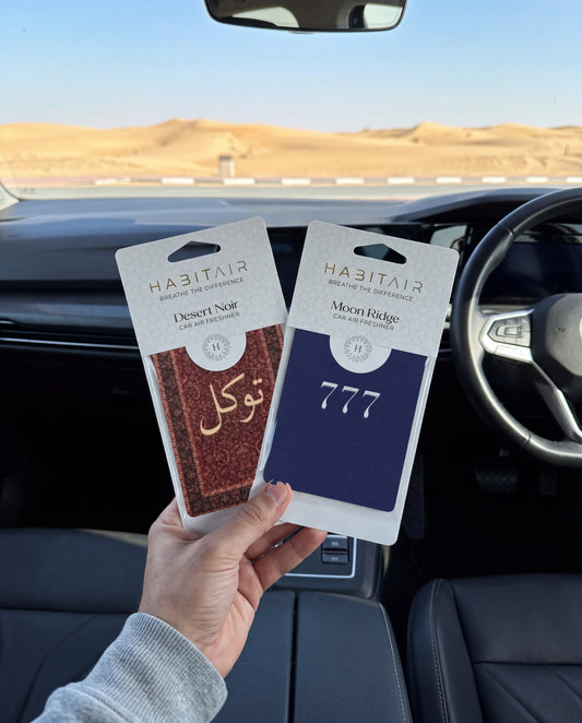 Balance & Luck DUO Bundle: hand holding the Tawakkul and Lucky 777 HabitAir retail packs in a car