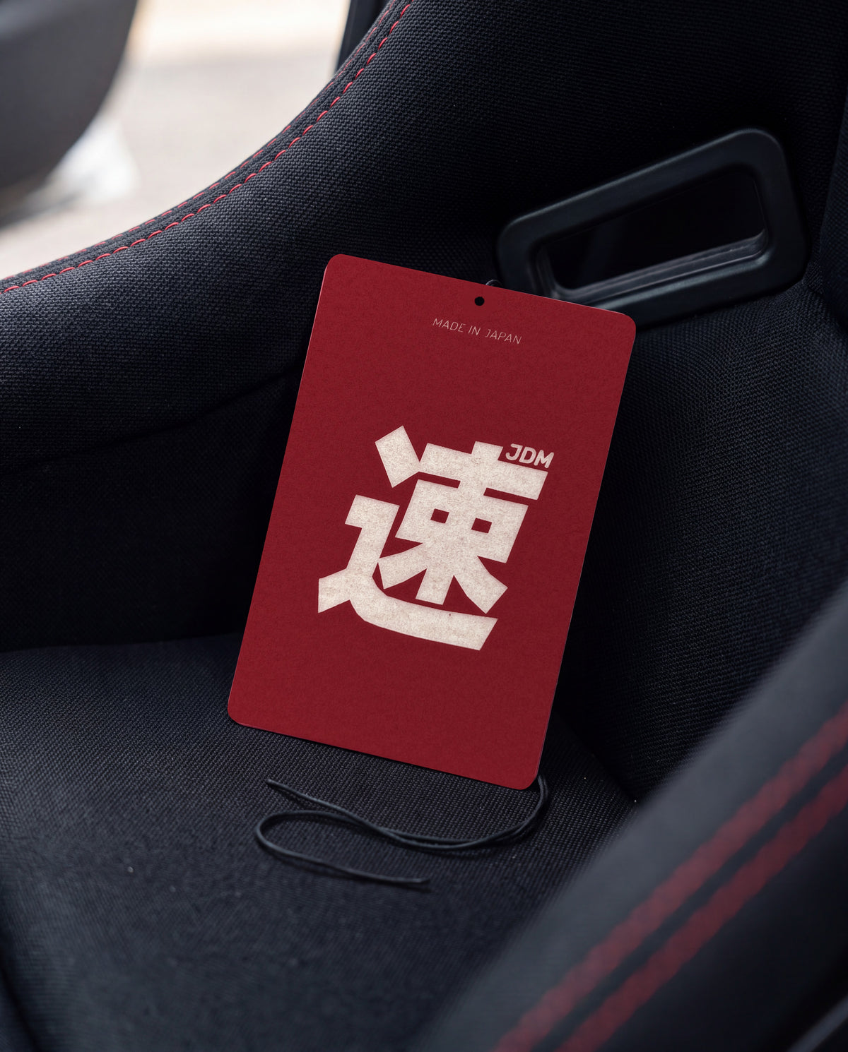 JDM Spirit car air freshener card on a car interior detail