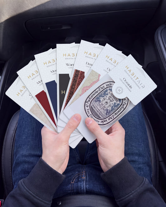 Habitair Ultimate Bundle – 7 Premium Car Air Fresheners: hand holding the all seven HabitAir designs HabitAir retail packs in a car