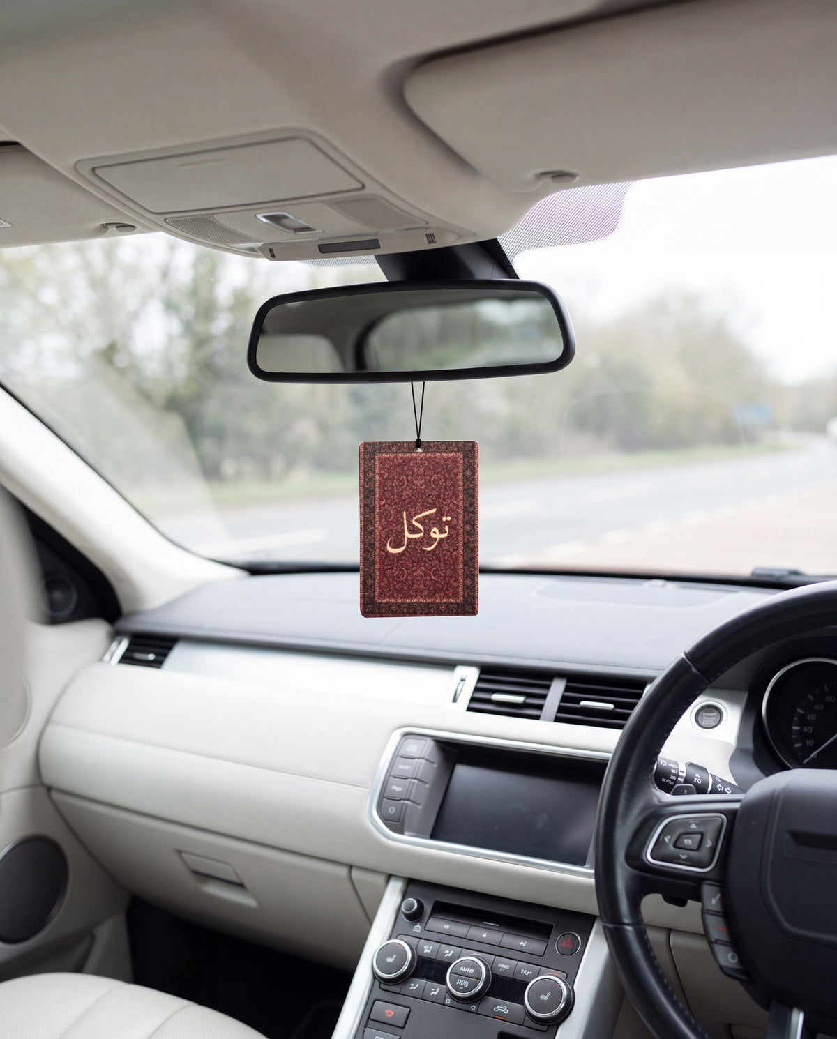 DESERT NOIR hanging from a car's rear-view mirror