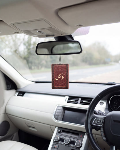 DESERT NOIR hanging from a car's rear-view mirror