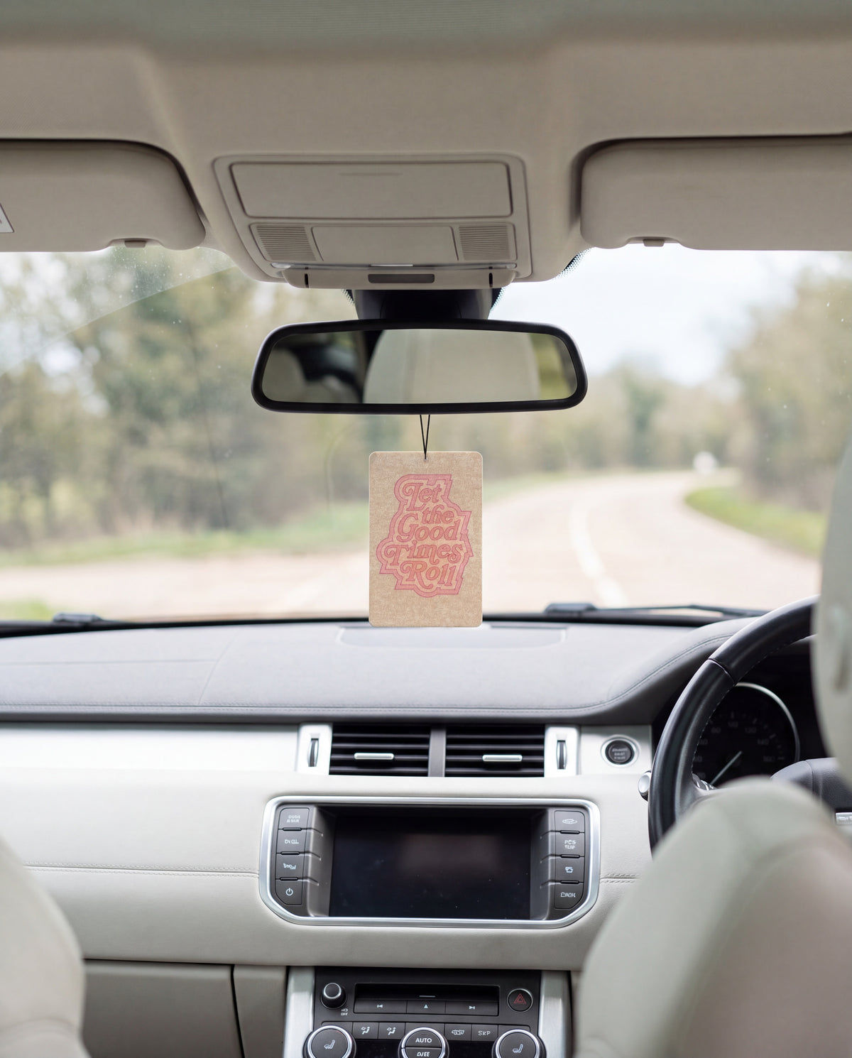 Let the Good Times Roll hanging from a car's rear-view mirror