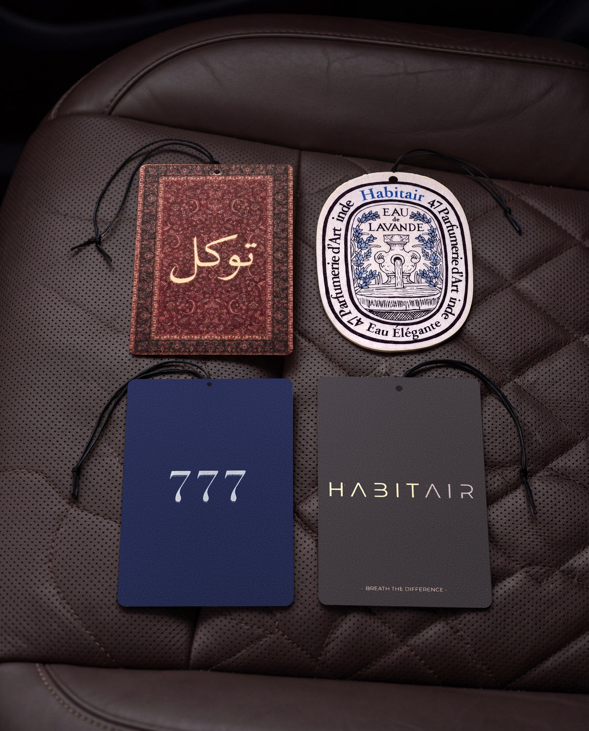 The Grand Tour Bundle: Buy 3 Get 1 Free: Tawakkul, Eau de Lavande, Lucky 777 and Habitair Classic car air freshener cards on a car interior detail