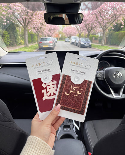 East Meets West DUO Bundle: hand holding the JDM Spirit and Tawakkul HabitAir retail packs in a car