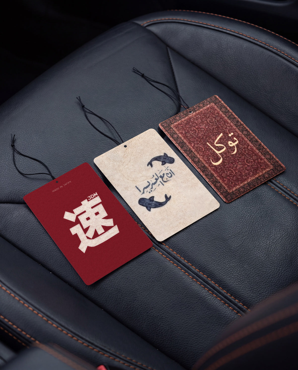 Habitair Trio: The CULTURE Collection: JDM Spirit, Ease in Every Journey and Tawakkul car air freshener cards on a car interior detail