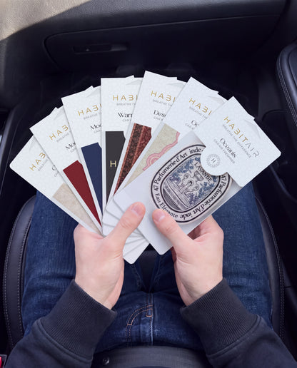 Habitair Ultimate Bundle – 7 Premium Car Air Fresheners: hand holding the all seven HabitAir designs HabitAir retail packs in a car