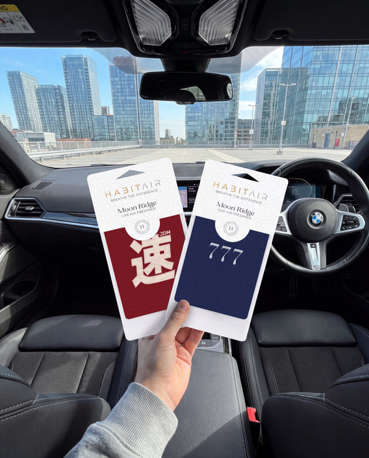 JDM x 777 - The Duo Bundle: hand holding the JDM Spirit and Lucky 777 HabitAir retail packs in a car