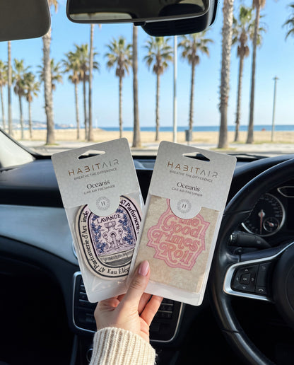 The Feel Good - DUO: hand holding the Eau de Lavande and Let the Good Times Roll HabitAir retail packs in a car