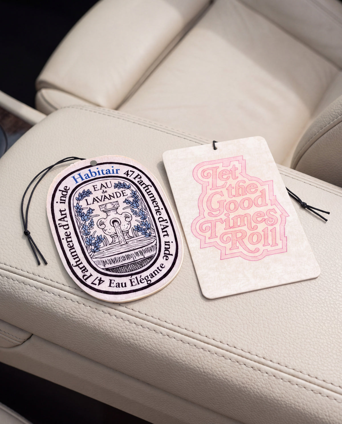 The Feel Good - DUO: Eau de Lavande and Let the Good Times Roll car air freshener cards on a car interior detail